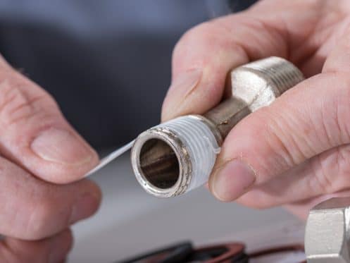 Plumber putting a teflon joint on a thread