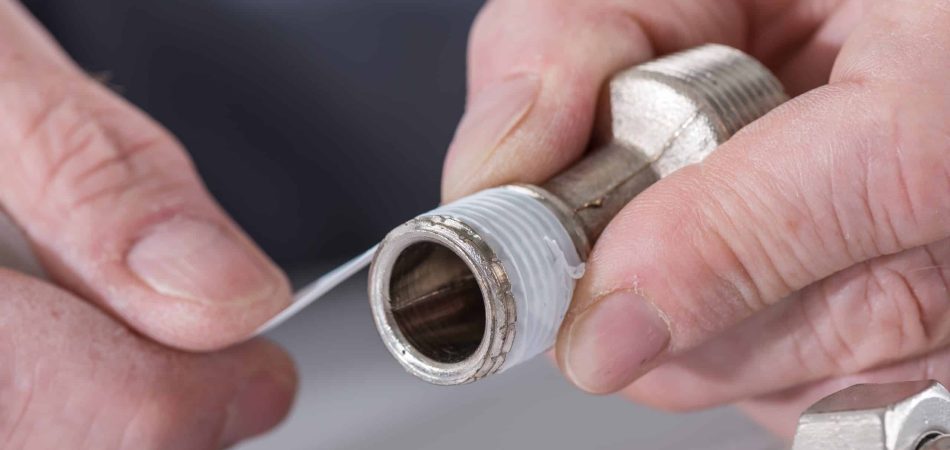 Plumber putting a teflon joint on a thread