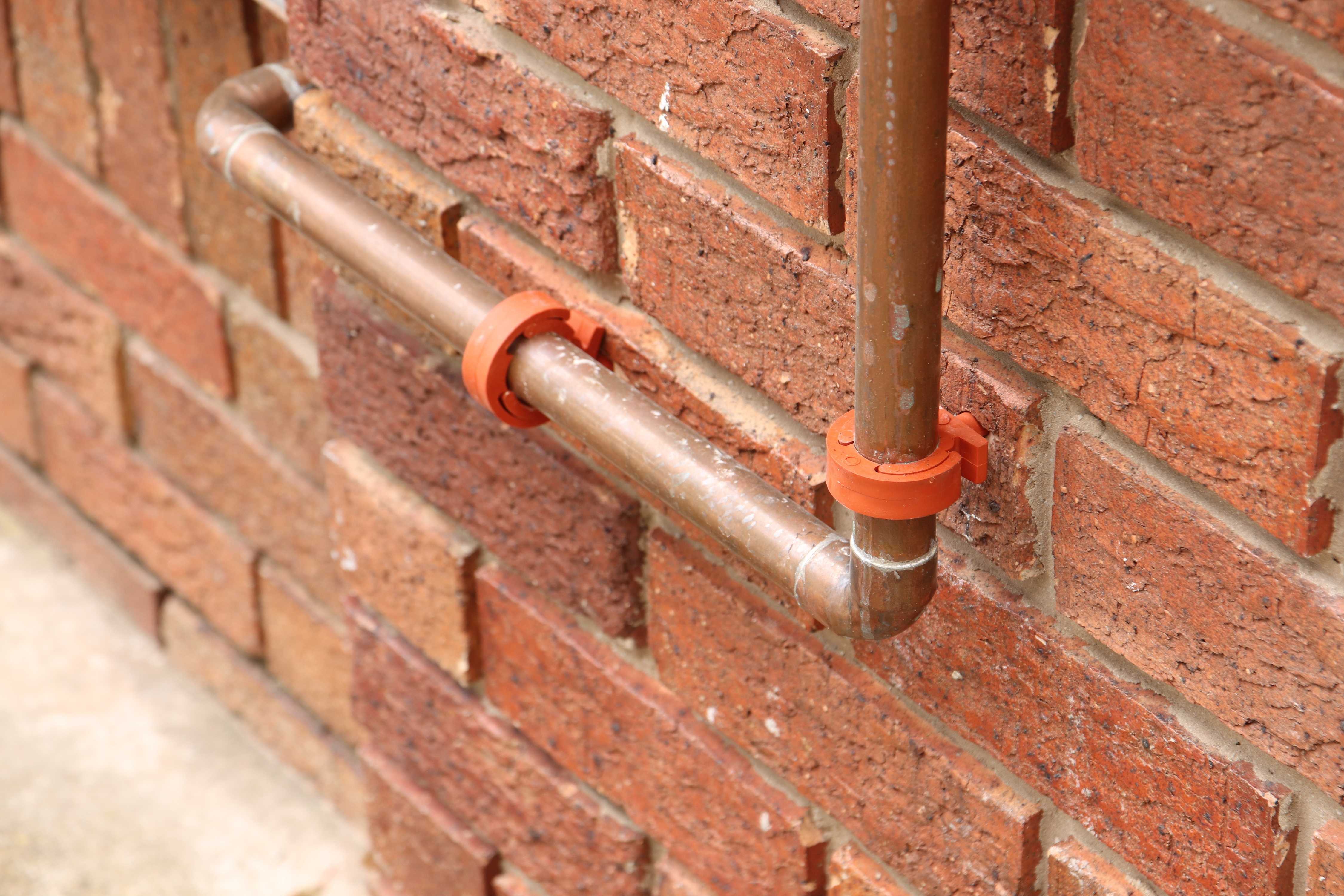 closeup of a copper pipeline with orange handles