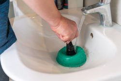male hands cleaning the blockage in the washbasin
