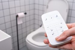 remote Control with buttons of the smart toilet bowl. high technology automatic modern flush toilet.