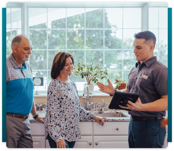 plumber talking to elder couple in the kitchen
