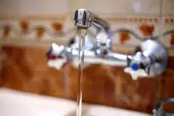 water runs from a tap into a kitchen sink