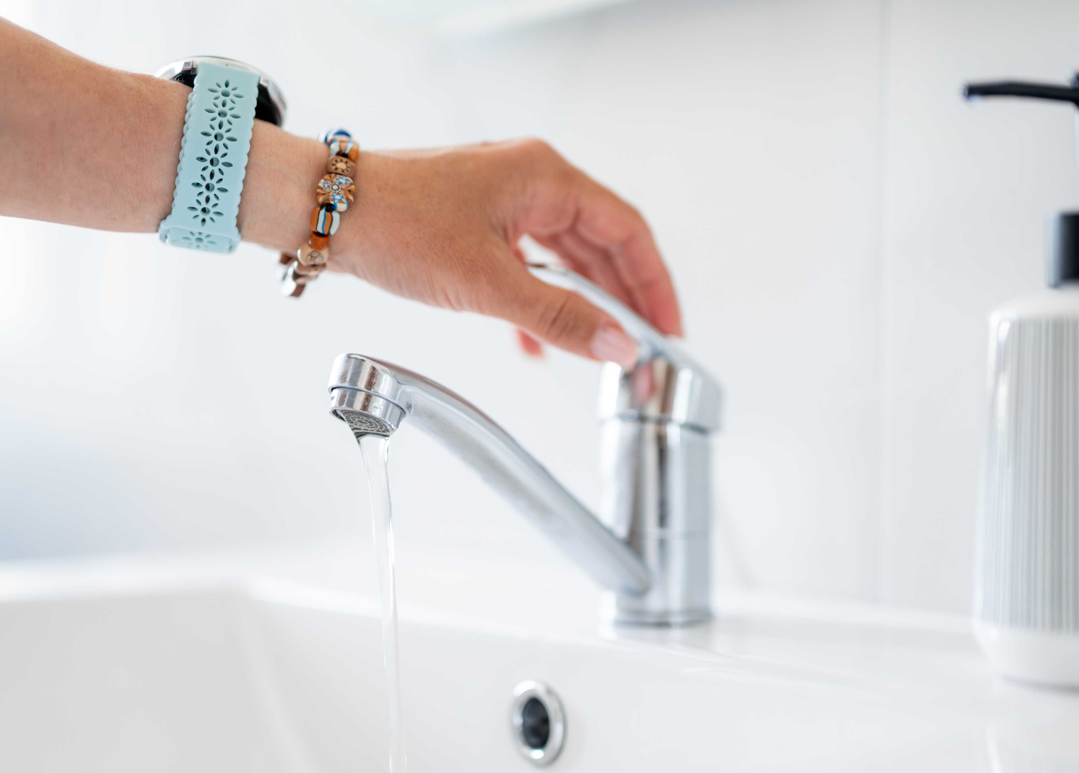 woman turning of water faucet
